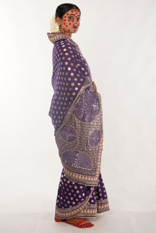 Woman wearing a handloom benarsi silk saree with gold patterns on a white background