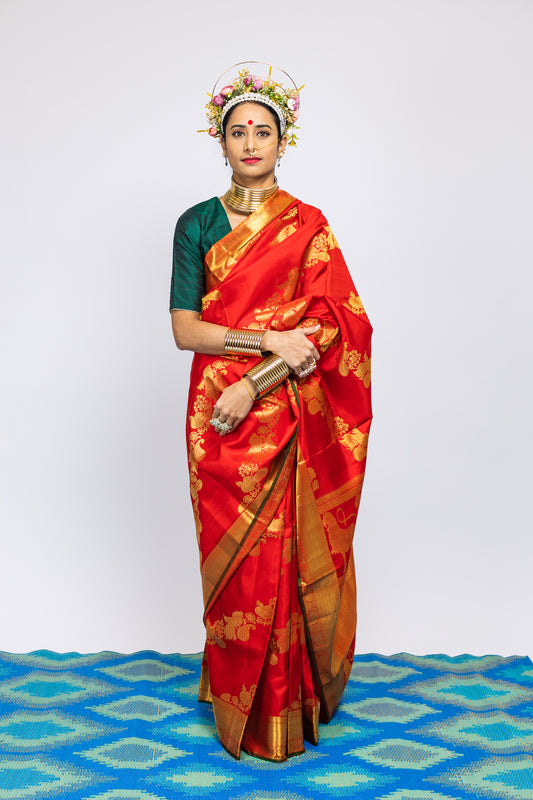 A woman wearing a red kanjiveram silk wedding saree designed by Ayush Kejriwal.
