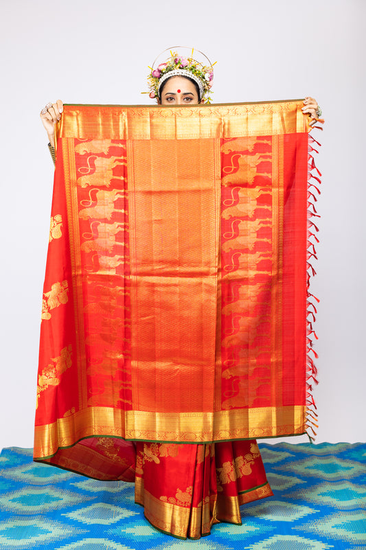 A woman wearing a red kanjiveram silk wedding saree designed by Ayush Kejriwal.