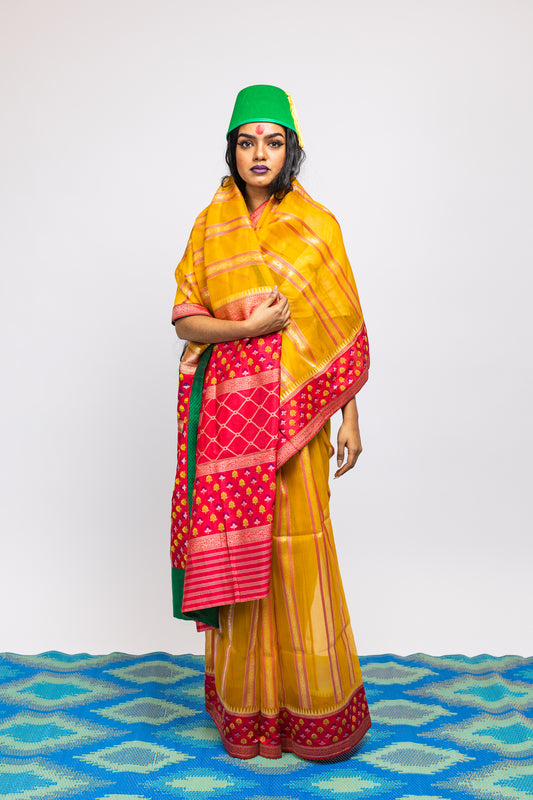 A woman wearing a yellow handwoven Cora benarsi silk saree designed by Ayush Kejriwal.