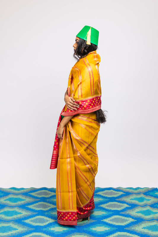 A woman wearing a yellow handwoven Cora benarsi silk saree designed by Ayush Kejriwal.