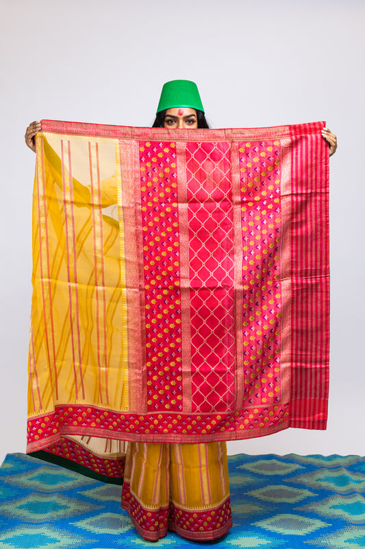 A woman wearing a yellow handwoven Cora benarsi silk saree designed by Ayush Kejriwal.