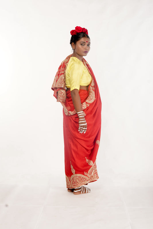 A woman wearing a red embroidered wedding saree designed by Ayush Kejriwal.