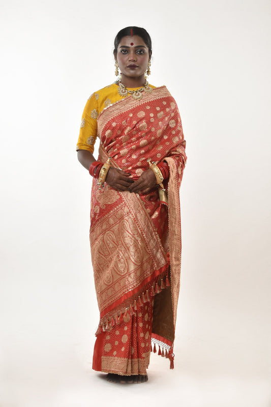 A woman wearing a red benarsi silk wedding saree designed by designer Ayush Kejriwal.
