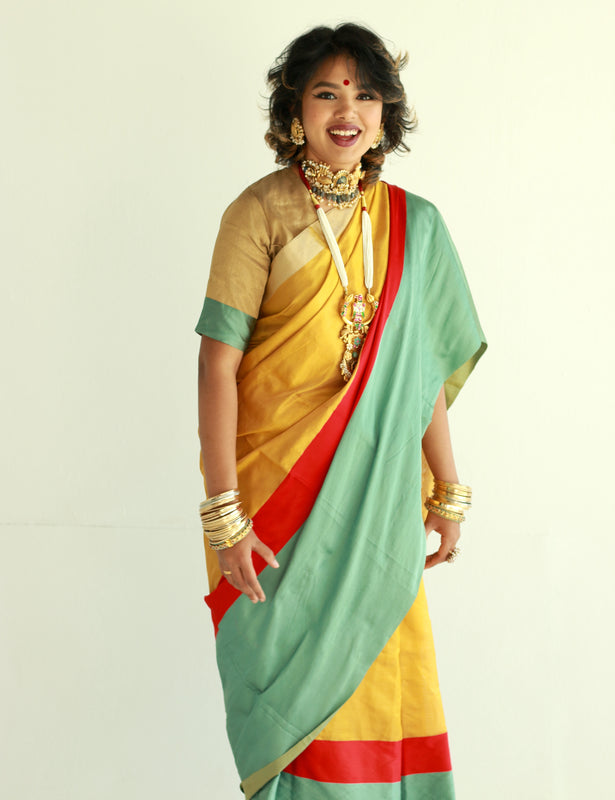 A woman wearing a handwoven gold chanderi silk saree designed by Ayush Kejriwal.