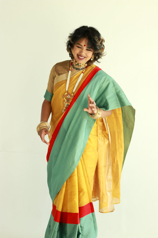 A woman wearing a handwoven gold chanderi silk saree designed by Ayush Kejriwal.