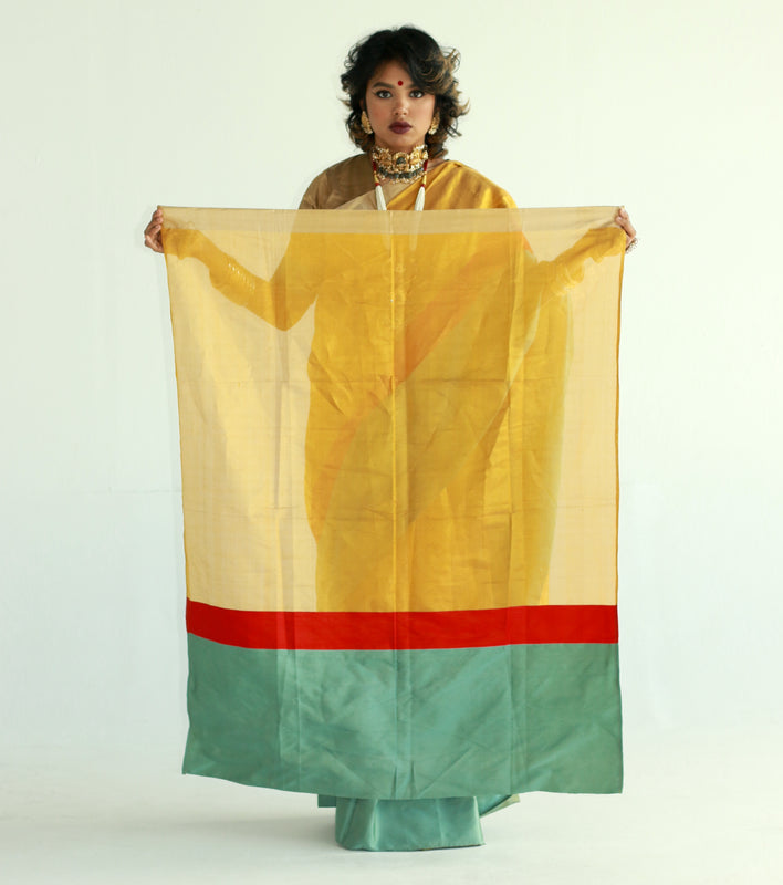 A woman wearing a handwoven gold chanderi silk saree designed by Ayush Kejriwal.