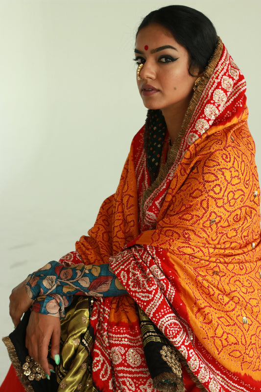 A woman wearing an Indian wedding bandhani dupatta designed by Ayush Kejriwal.