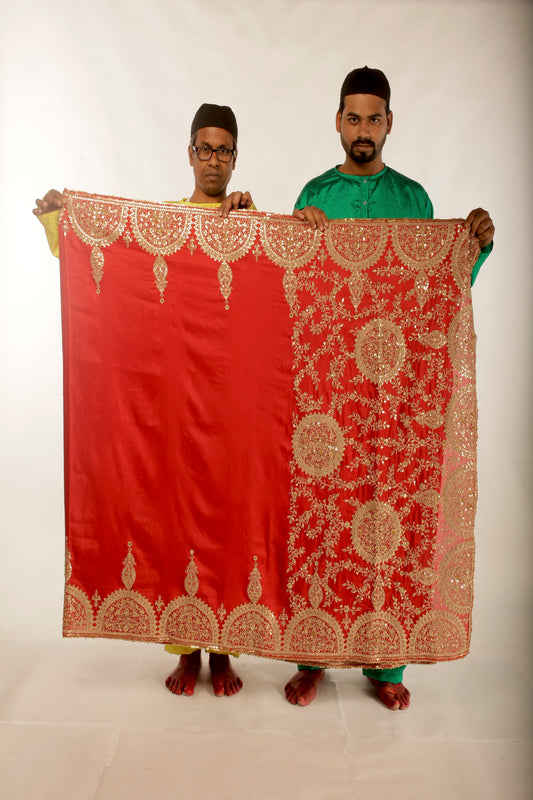 A woman wearing a red embroidered wedding saree designed by Ayush Kejriwal.
