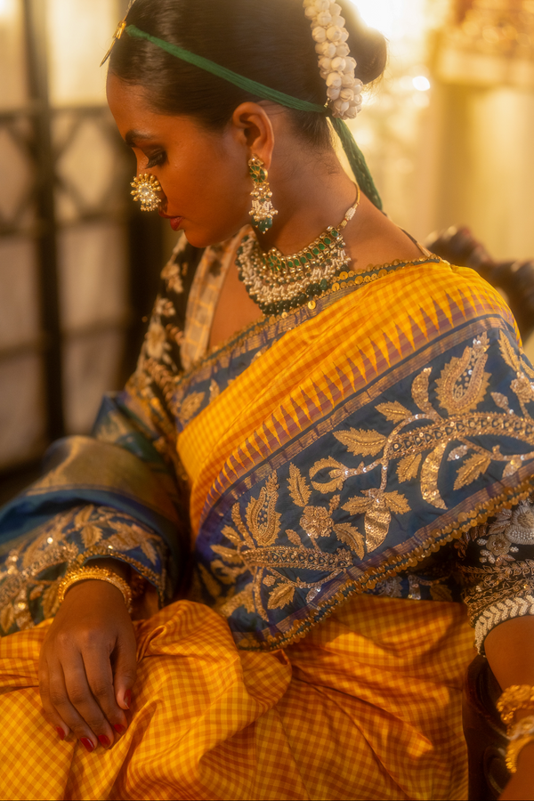 Woman in traditional yellow and blue kanjiveeram silk saree with jewellery