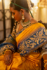 Woman in traditional yellow and blue kanjiveeram silk saree with jewellery
