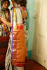 Woman wearing a  traditional beautiful handwoven English grey and antique gold Kanjiveeram silk saree  with a mirror reflection in the background