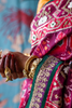 Close-up of a pink embroidered patola silk saree with a green border.
