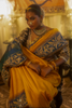 Woman in a yellow kanjiveeram silk saree in an indoor setting