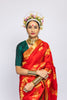 A woman wearing a red kanjiveram silk wedding saree designed by Ayush Kejriwal.