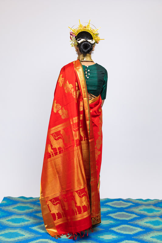 A woman wearing a red kanjiveram silk wedding saree designed by Ayush Kejriwal.