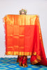 A woman wearing a red and gold kanjiveram silk wedding saree designed by Ayush Kejriwal.