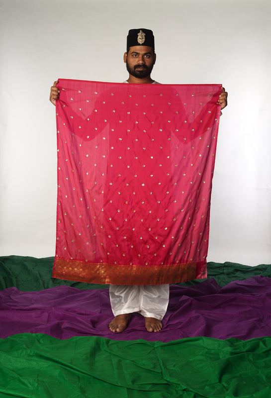 A man showing a hand woven benarsi silk blouse piece  designed by Ayush Kejriwal.