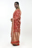 A woman wearing a red benarsi silk wedding saree designed by designer Ayush Kejriwal.