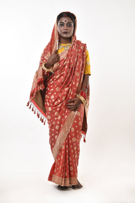 A woman wearing a red benarsi silk wedding saree designed by designer Ayush Kejriwal.