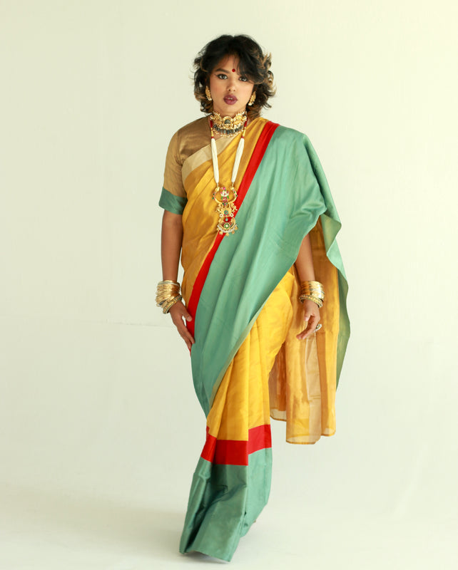 A woman wearing a handwoven gold chanderi silk saree designed by Ayush Kejriwal.