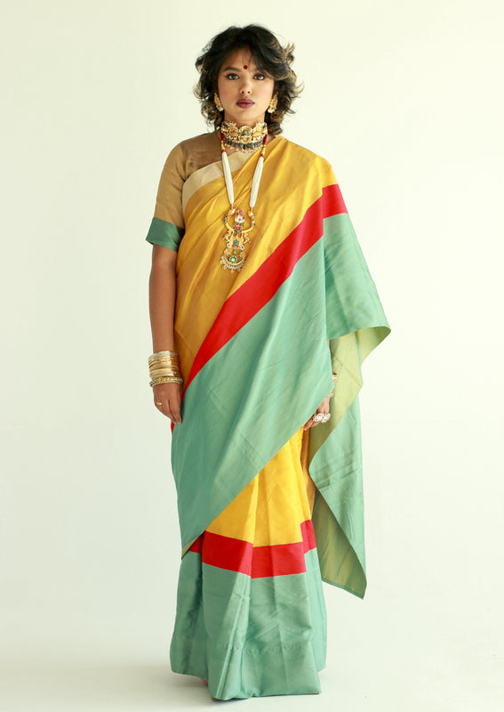 A woman wearing a handwoven gold chanderi silk saree designed by Ayush Kejriwal.