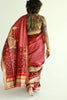 A woman wearing a red embroidered patola silk saree designed by Ayush Kejriwal.