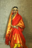A woman wearing a red and gold kanjiveram silk wedding saree designed by Ayush Kejriwal.