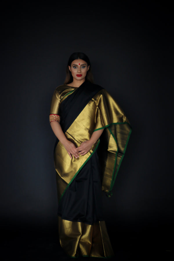 A woman wearing a handwoven black and gold kanjiveram silk saree designed by Ayush Kejriwal.